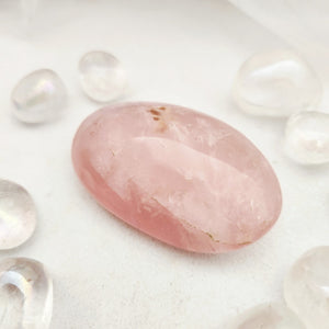 Smooth rose quartz palm stone with soft pink tone and oval shape