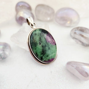 Oval ruby in zoisite pendant in stepped sterling silver bezel setting with bail