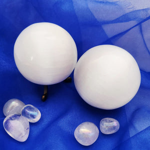 Smooth white selenite sphere with soft satin sheen and rounded form.
