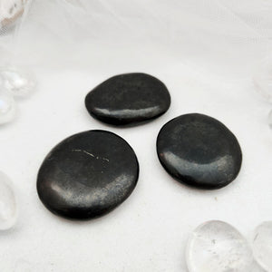 Flat shungite stone with a smooth, dark polished surface