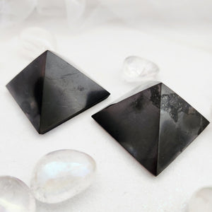Black shungite pyramid with smooth, polished sides and sharp edges