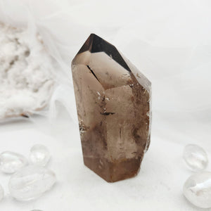 Polished smoky quartz point with tall faceted form and rich brown tone