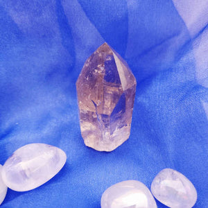 Smoky quartz point with faceted tip and tapered form.