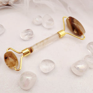 Tigerskin glass face roller with gold-tone handle and forked ends.