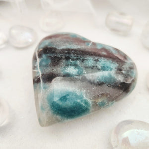 Polished trolleite heart with mottled teal and grey-purple patterning