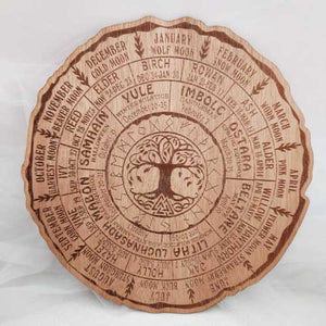 Round wooden pendulum board engraved with a celtic tree of life.