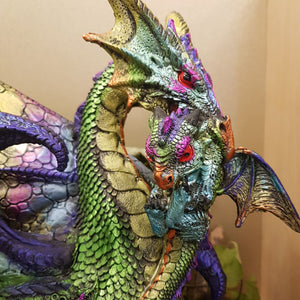 Multi Coloured Dragon Standing With Baby In Mouth