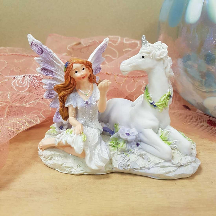 Purple Fairy sitting with Unicorn