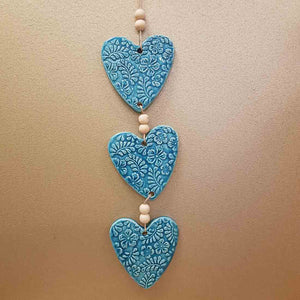 3 Turquoise Coloured Embossed Hearts on a String with Beads. (approx. 38 x 8cm to top of string)