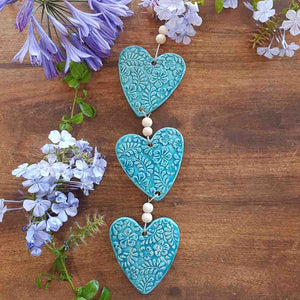 3 Turquoise Coloured Embossed Hearts on a String with Beads. (approx. 38 x 8cm to top of string)