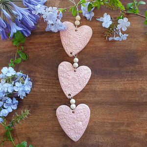 3 Pink Embossed Hearts on a String with Beads. (approx. 38 x 8cm to top of string)
