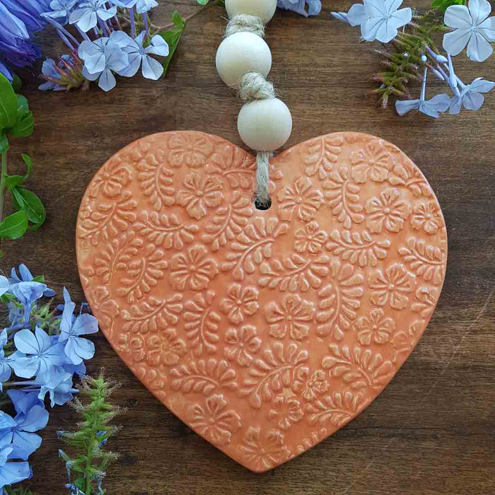 Orange Embossed Ceramic Heart with Wooden Beads. (approx. 30x17cm incl. string)