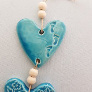 Turquoise 3 Embossed Hearts With Footprints on a String with Beads