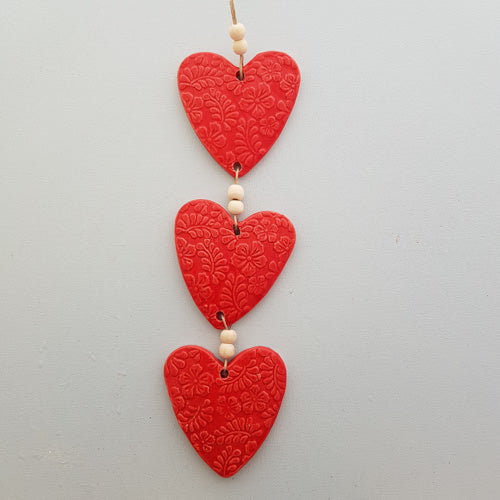 Red Coloured Embossed Hearts 3 on a String with Beads. (approx. 38 x 8cm to top of string)