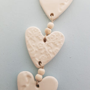 White 3 Embossed Hearts With Footprints on a String with Beads