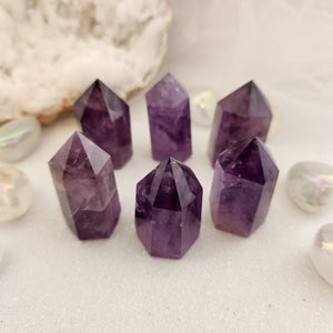 Polished amethyst point showing smooth surfaces and purple colouring