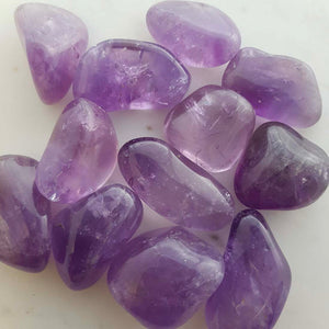 Polished amethyst tumbled stone with soft purple tones.