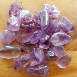 Polished amethyst tumbled stone with soft purple tones.