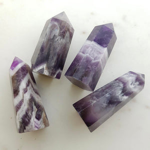 Chevron amethyst polished point showing purple and white banding.