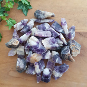Small chevron amethyst rough point with natural purple and white bands.
