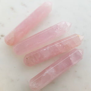 Faceted rose quartz wand in soft pale pink with pointed tip