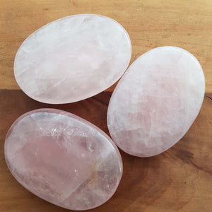 Smooth oval rose quartz palm stone in soft pale pink