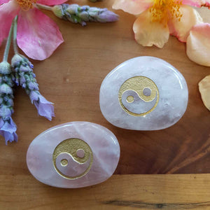 Polished rose quartz Yin Yang flat stone in soft pink tones.